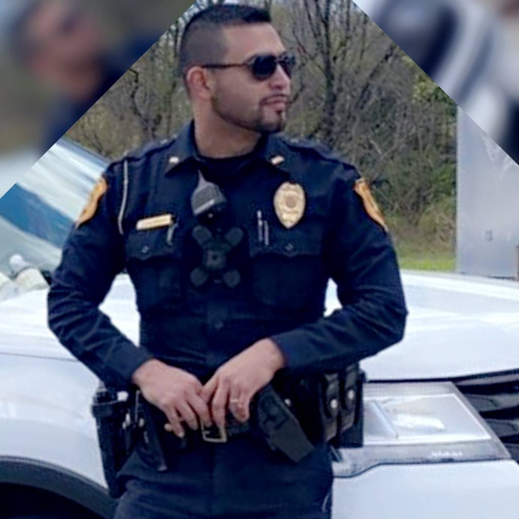 Officer Bernal rests against patrol vehicle